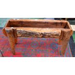 A naturalistic planter, composed of various splits of barked timber, pine lined,