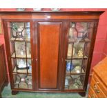 An Edwardian mahogany display cabinet, ogee cornice, fielded panel central door enclosing shelving,