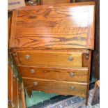 An oak bureau, fall front enclosing pigeon holes over three drawers, brass roundel escutcheons,