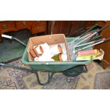 A wheelbarrow containing garden tools including Wilkinson Sword loppers;
