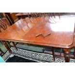 A late Victorian mahogany extending dining table, rounded rectangular top, reeded tapered legs,