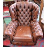 A Chesterfield type wingback armchair, deep buttoned upholstery, scroll arms,