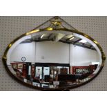 An Adam style brass framed wall mirror, oval bevelled plate crested by an urn,