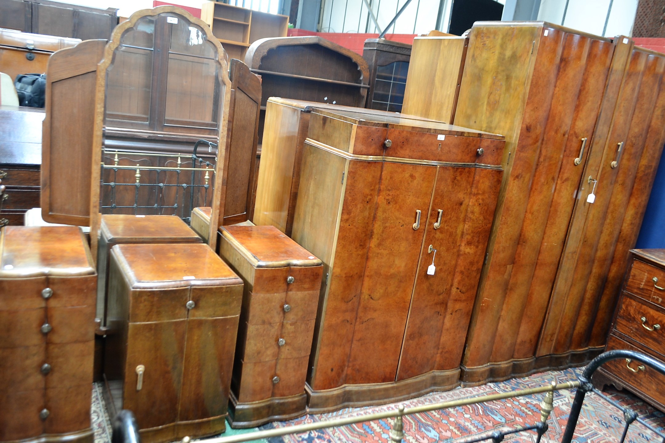 An Art Deco style walnut bedroom suite comprising wardrobes,