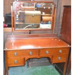 An Edwardian mahogany bedroom suite comprising triple wardrobe,