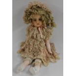 A 19th century style wax doll, blue glass eyes, open mouth, red lips, long blond curly hair,