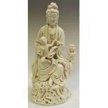 A Chinese blanc de chine figure, of Guanyin, possibly 18th/19th century,holding a child,