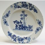 A Delft circular plate, painted in underglaze blue with bamboo and peonies, 23cm diam, c.