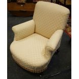 A Victorian low armchair, padded back and seat, scrolling arms, turned forelegs, brass casters.