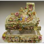 A large and decorative Capo-di-Monte grand piano, encrusted overall with flowers and foliage,