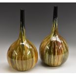 A pair of Bretby Art Pottery onion shaped bottle vases, drip glazed in mottled shades of green,
