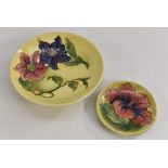 A Moorcroft Clematis pattern pedestal dish, tube lined with blue and red flowers on a yellow ground,