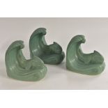 A pair of Langley Mill Pottery stylised fish bookends, each being swept along on a cresting wave,