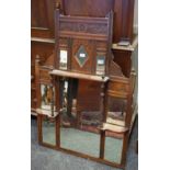 A mahogany overmantel mirror, an arrangement of seven mirrors flanked by carved panels,