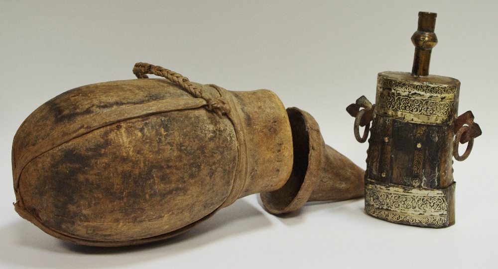 A tribal gourd water vessel and cover; a late 19th/early 20th century Indian powder flask,