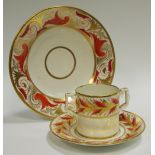 A Derby chocolate cup and stand, painted with bands of orange and gilt leaves, angular handle,