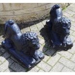A pair of black painted reconstituted garden lions,