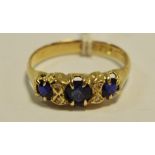 An 18ct gold 'gypsy' ring set with three blue sapphires 2.