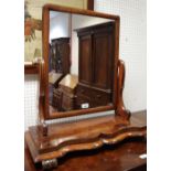 A 19th century mahogany dressing mirror, rectangular plate, scroll supports, serpentine base,