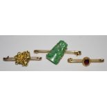 A 9ct gold bar brooch set with a carved jade stone in the form of two love birds;