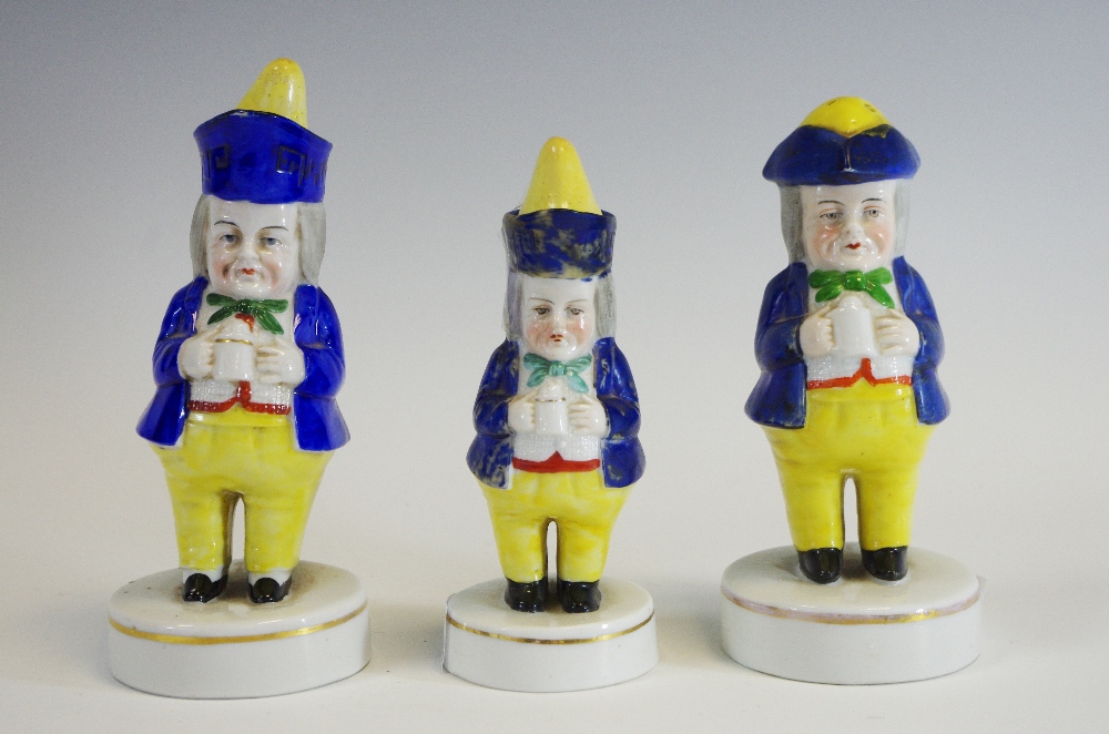 A Staffordshire Porcelainious caster, of a Jolly Toper, wearing a tricorn hat, holding a a mug,