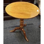 A mahogany oval tripod tilt-top table