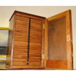 A twenty five section coin collectors cabinet.