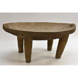 Antiquities - a Pre-Columbian stone metate, the dished oval top with masks to ends,