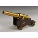 A 19th century bronze desk model signal canon, shaped oak carriage, brass wheels,