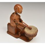 A Japanese boxwood Kobe toy automaton, as a comical figure playing a drum, 12cm long,