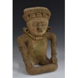 A Central American terracotta figure, in typical Pre-Columbian manner, seated, stylised features,