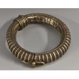 An Eastern silver coloured metal bangle,