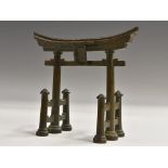 A Japanese dark patinated bronze model of a torii gate, 12cm wide, signed,