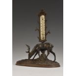 A 19th century cast iron table thermometer, as a stag grazing beside a tree, oval base, 22cm wide,