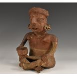 A Central American terracotta figure, in the typical Pre-Columbian manner, seated, cross-legged,
