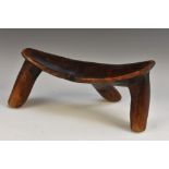 Tribal Art - a Dinka headrest, of good patination and typical one-piece three-legged form,