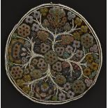 A circular beadwork panel, colourfully worked with stylised flowering branches,