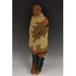 A Native American softwood and composition doll, of a tribal chief, he stands, wrapped in a blanket,