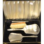 An early 20th century silver four piece dressing table set, mirror, comb and brushes,