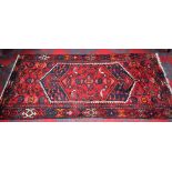 An Iranian hand made carpet/rug, stylised birds and geometric motifs on a scarlet ground,