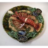 A Palissy style lobster plate, in relief with lobster and shells, impressed indistinct makers mark,