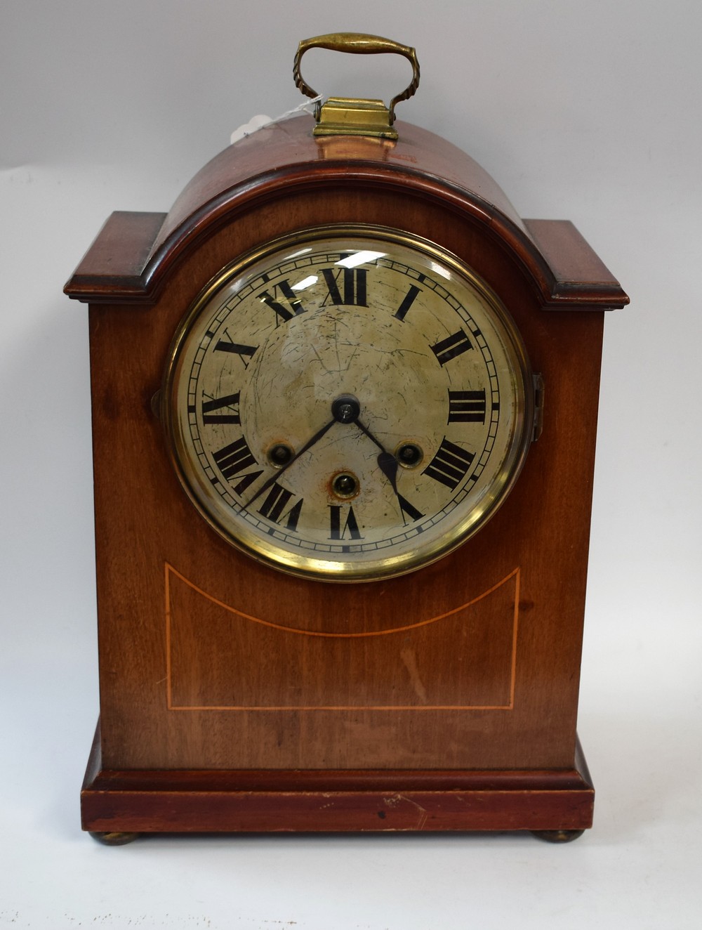 An Edwardian mahogany inlaid bracket clock, circular face with Roman numerals, minute track,