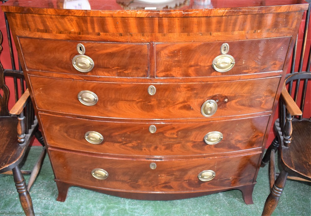 An early Victorian flame mahogany bow-front chest of two short over three long graduated cockbeaded