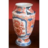 A Japanese pedestal vase, decorated in the Imari palette with Dragons and mythical birds,