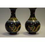 A pair of late 19th century cloisonne enamel vases depicting a ferocious dragon chasing the flaming