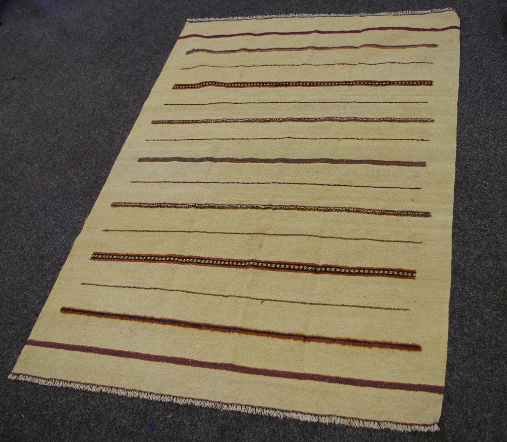 A hand woven Kilim rug, banded design on a cream ground.