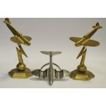 A pair of Art Deco brass models or mascots, each cast as a jet above a thunderbolt; another,