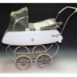A vintage Tri-ang tin plate dolls pram, white body and spring cradle, double folding canopy,