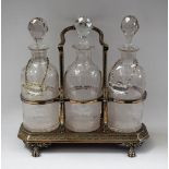 A silver plated three bottle tantalus with etched glass bottles