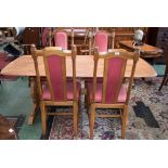 An Ercol elm dining table, well figured rounded rectangular top, vasular shaped end supports,